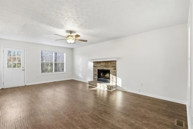 a view of an empty room with a window and fireplace