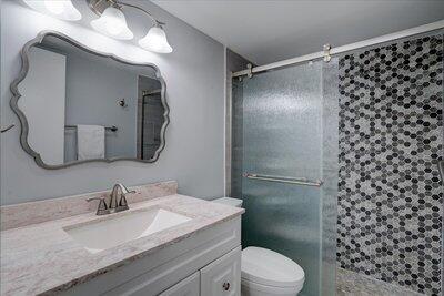 2018 South Federal Highway, Unit A301 Boynton Beach, FL 33435 - Photo 15 of 32 a bathroom with a granite countertop sink toilet and shower
