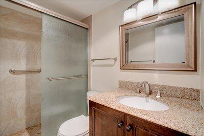 2018 South Federal Highway, Unit A301 Boynton Beach, FL 33435 - Photo 20 of 32 a bathroom with a granite countertop sink toilet and mirror