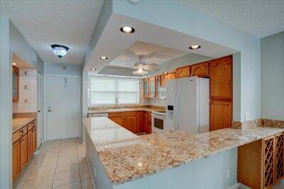 2018 South Federal Highway, Unit A301 Boynton Beach, FL 33435 - Photo 5 of 32 a kitchen with stainless steel appliances granite countertop a sink stove and refrigerator