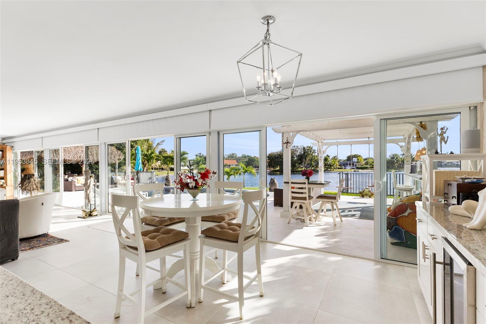 6830 Winged Foot Drive Hialeah, FL 33015 - Photo 13 of 28 a view of a dining room with furniture large windows and a chandelier