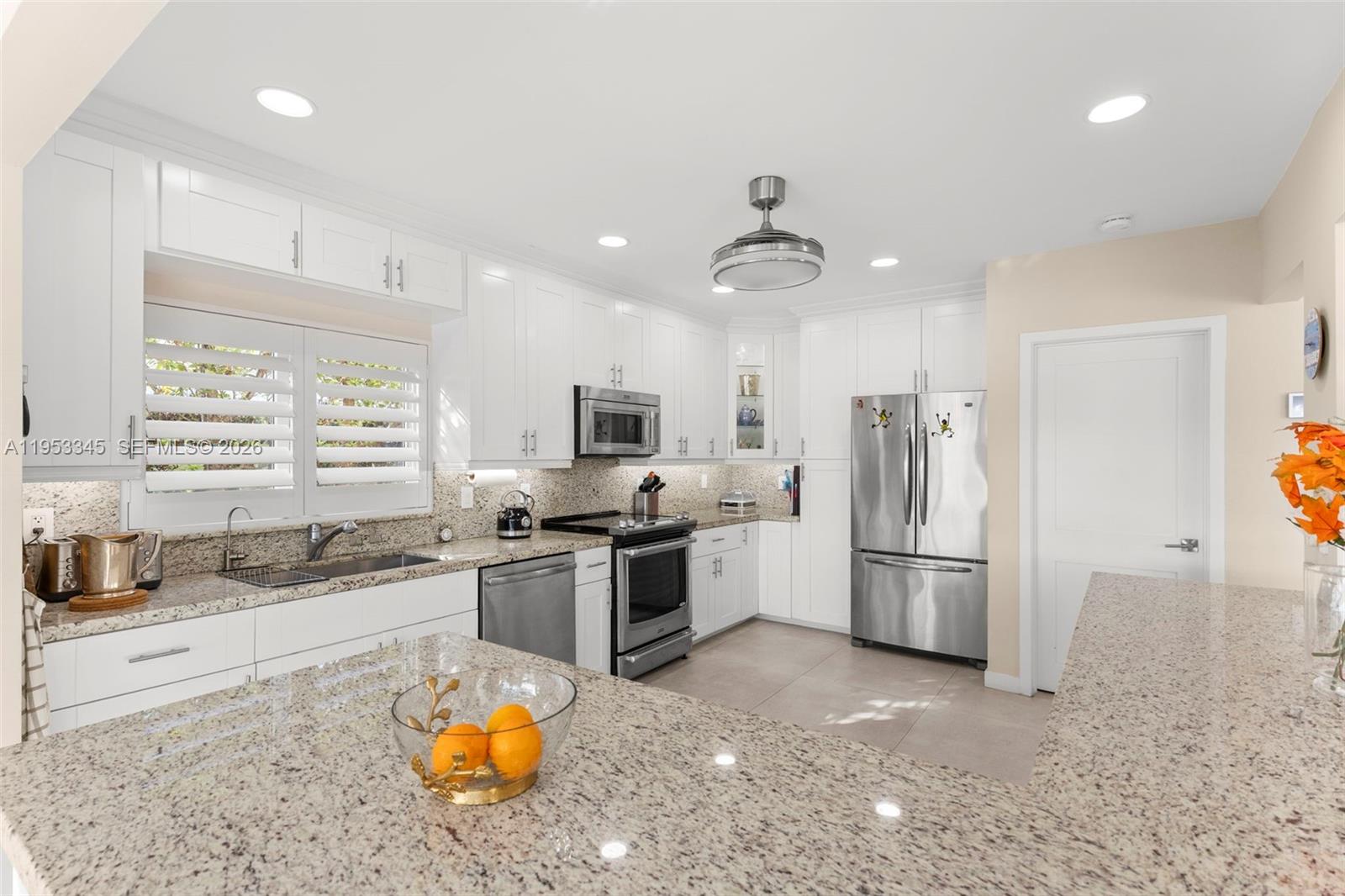 6830 Winged Foot Drive Hialeah, FL 33015 - Photo 28 of 28 a kitchen with stainless steel appliances a refrigerator a stove a sink and white cabinets