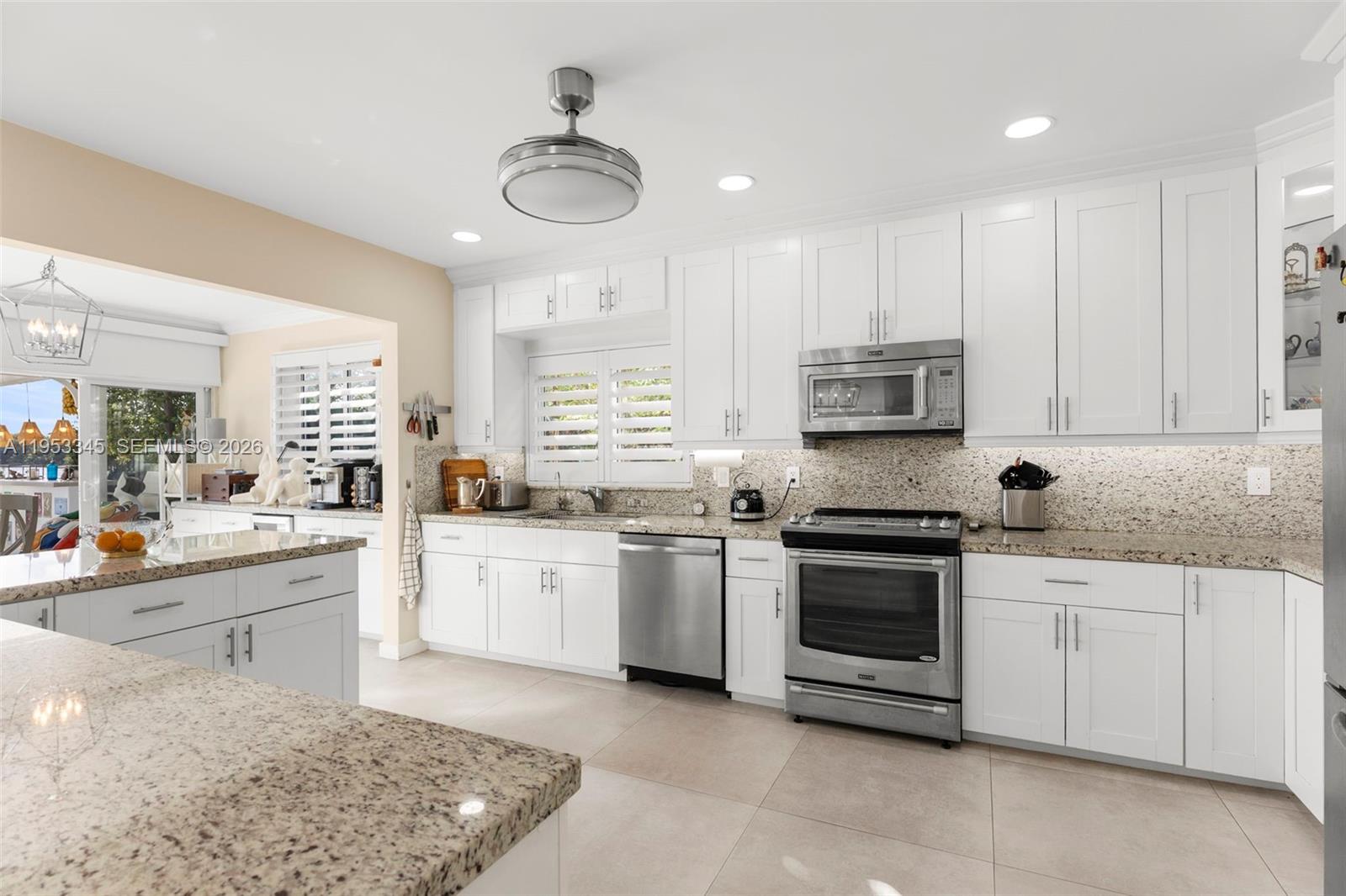 6830 Winged Foot Drive Hialeah, FL 33015 - Photo 9 of 28 a large white kitchen with stainless steel appliances granite countertop a stove and a sink