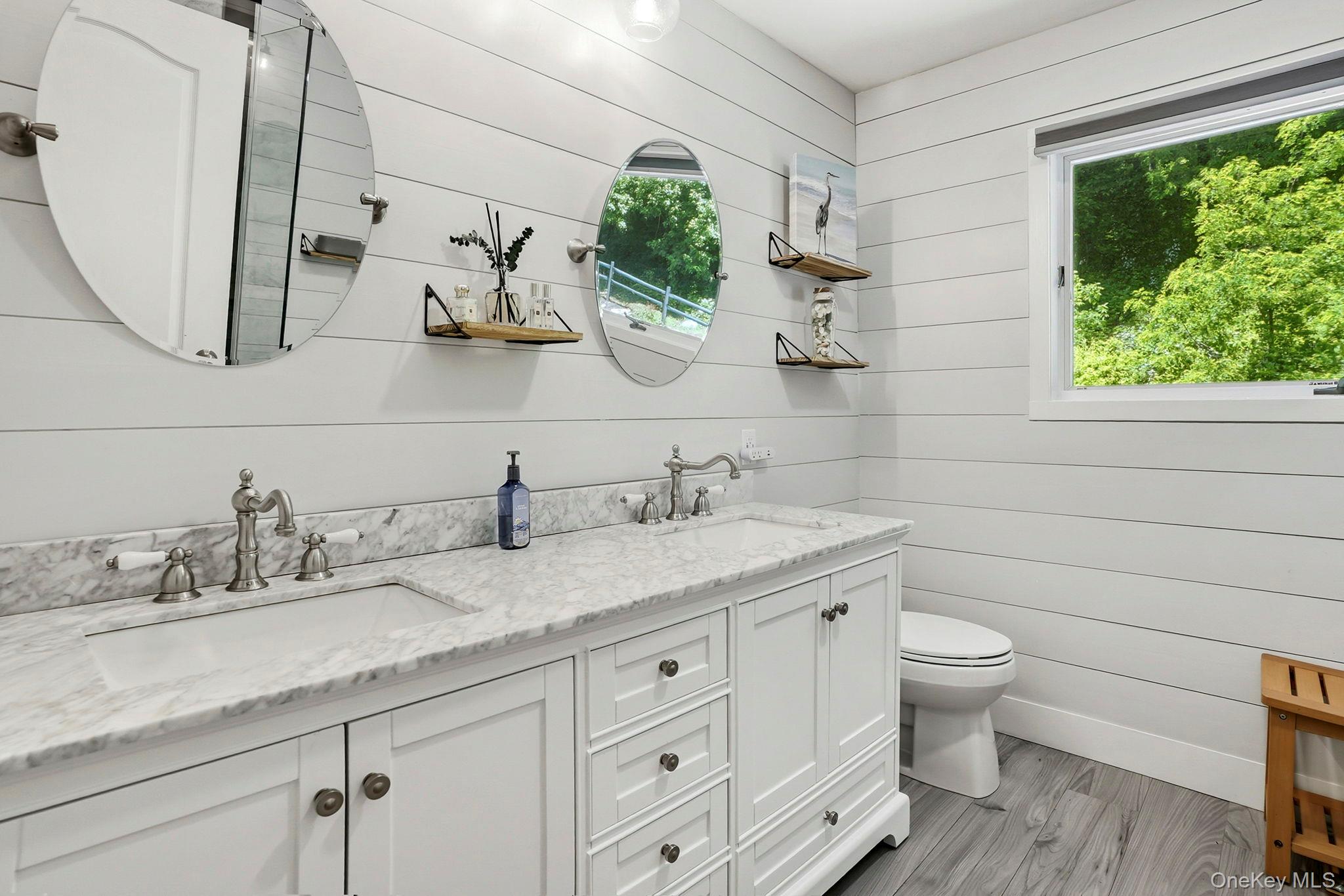 31 Ridge Road Cortlandt Manor, NY 10567 - Photo 29 of 39 Lovingly updated in 2022 (est.), the primary bath has double sinks with a marble counter over a large vanity base.