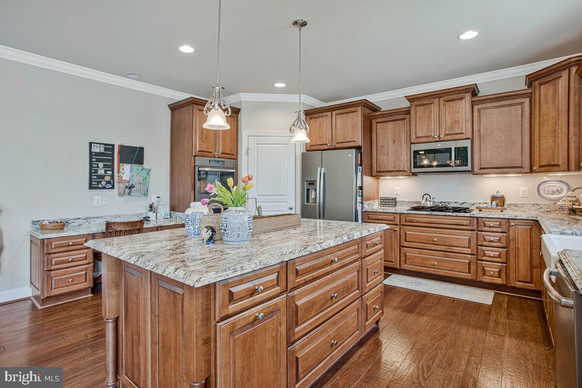 54 Simmons Ridge Road Prince Frederick, MD 20678 - Photo 18 of 55 a kitchen with kitchen island granite countertop a sink cabinets and wooden floor