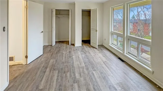 a view of a big room with wooden floor windows and entrance