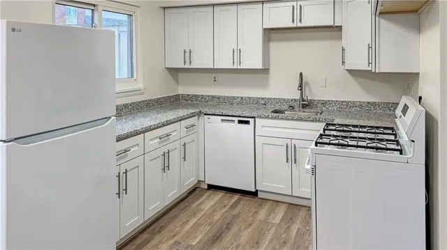 a kitchen with white cabinets and white appliances