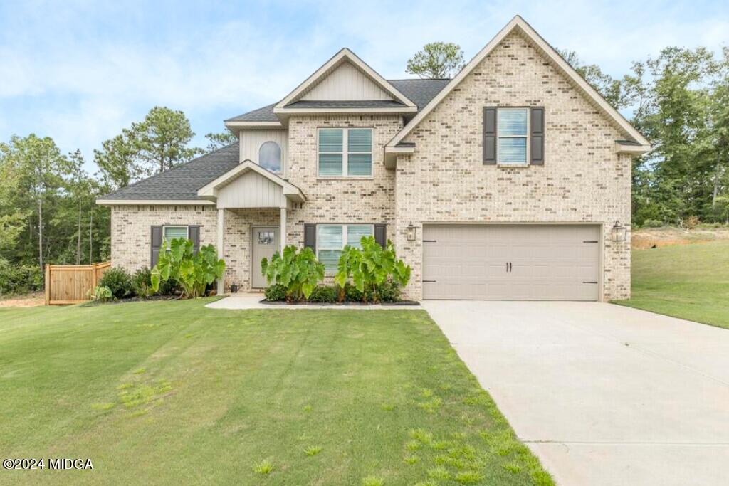 135 Timber Ridge Boulevard Byron, GA 31008 - Photo 1 of 36 a front view of a house with a yard and garage