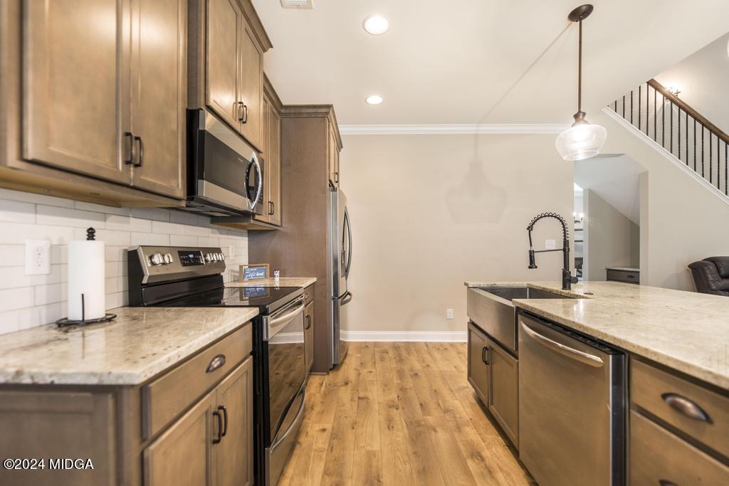135 Timber Ridge Boulevard Byron, GA 31008 - Photo 12 of 36 a kitchen with stainless steel appliances granite countertop a sink a microwave cabinets and wooden floor