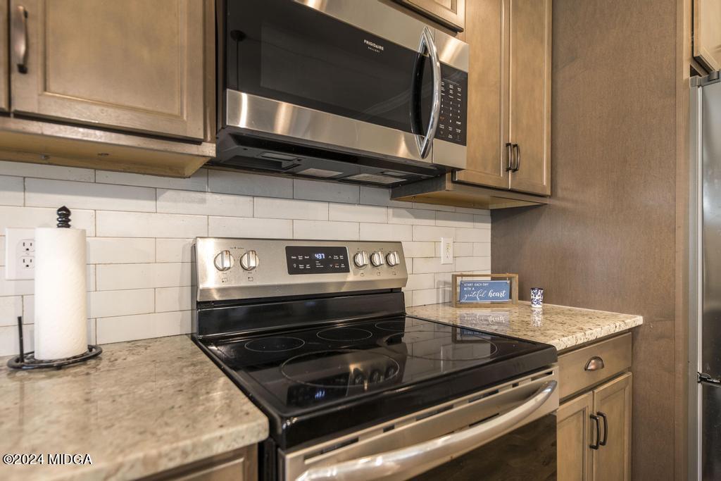 135 Timber Ridge Boulevard Byron, GA 31008 - Photo 13 of 36 a kitchen with stainless steel appliances granite countertop a stove and a microwave