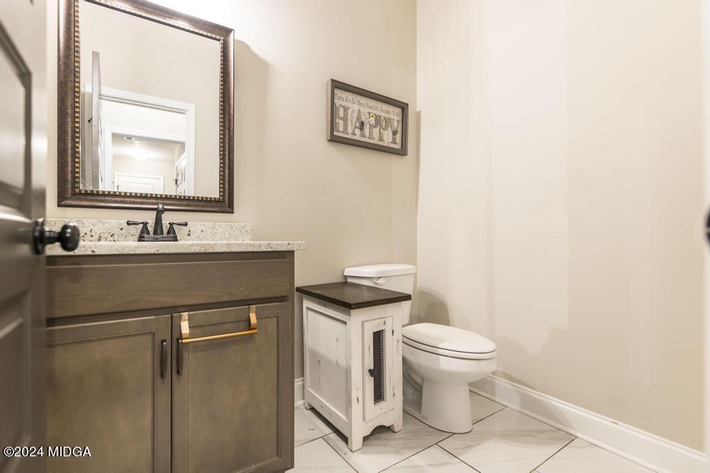 135 Timber Ridge Boulevard Byron, GA 31008 - Photo 15 of 36 a bathroom with a toilet sink vanity and mirror