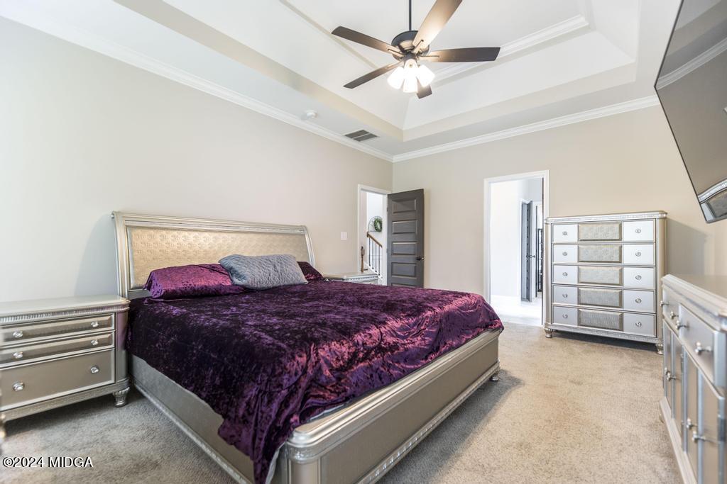 135 Timber Ridge Boulevard Byron, GA 31008 - Photo 20 of 36 a bedroom with a bed a dresser and a chandelier
