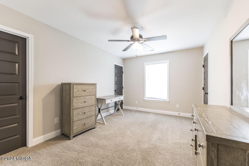 135 Timber Ridge Boulevard Byron, GA 31008 - Photo 27 of 36 a spacious bedroom with a bed and a chandelier