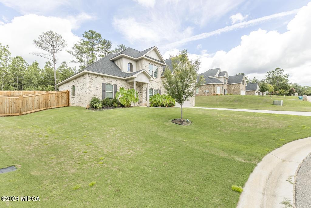 135 Timber Ridge Boulevard Byron, GA 31008 - Photo 3 of 36 a view of a white house with a big yard and potted plants