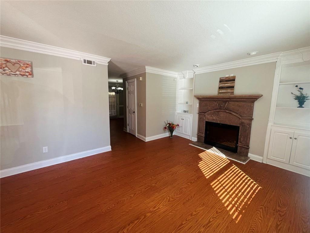 4430 Tilly Mill Road, Unit 104 Dunwoody, GA 30360 - Photo 16 of 37 a view of empty room with wooden floor and fireplace