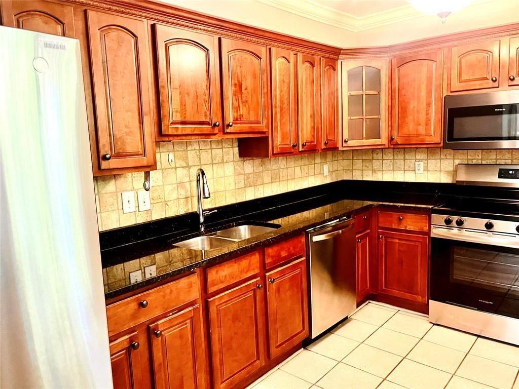 4430 Tilly Mill Road, Unit 104 Dunwoody, GA 30360 - Photo 22 of 37 a kitchen with stainless steel appliances granite countertop a stove a sink and a microwave