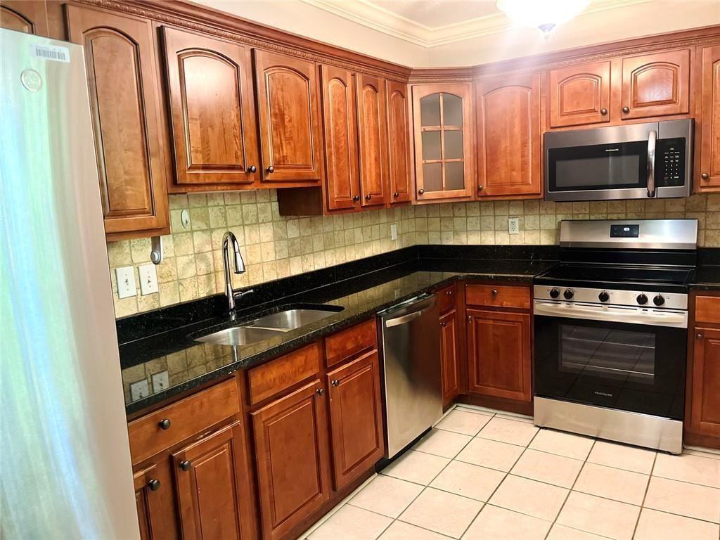 4430 Tilly Mill Road, Unit 104 Dunwoody, GA 30360 - Photo 23 of 37 a kitchen with stainless steel appliances granite countertop a stove a sink and a microwave