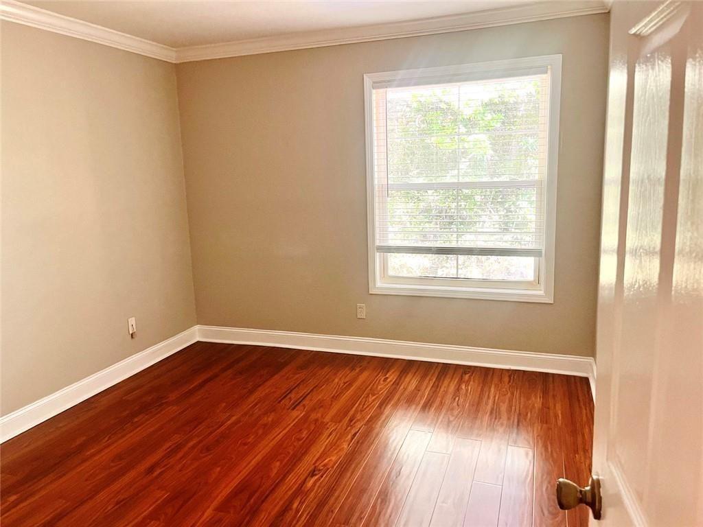 4430 Tilly Mill Road, Unit 104 Dunwoody, GA 30360 - Photo 29 of 37 an empty room with wooden floor and windows