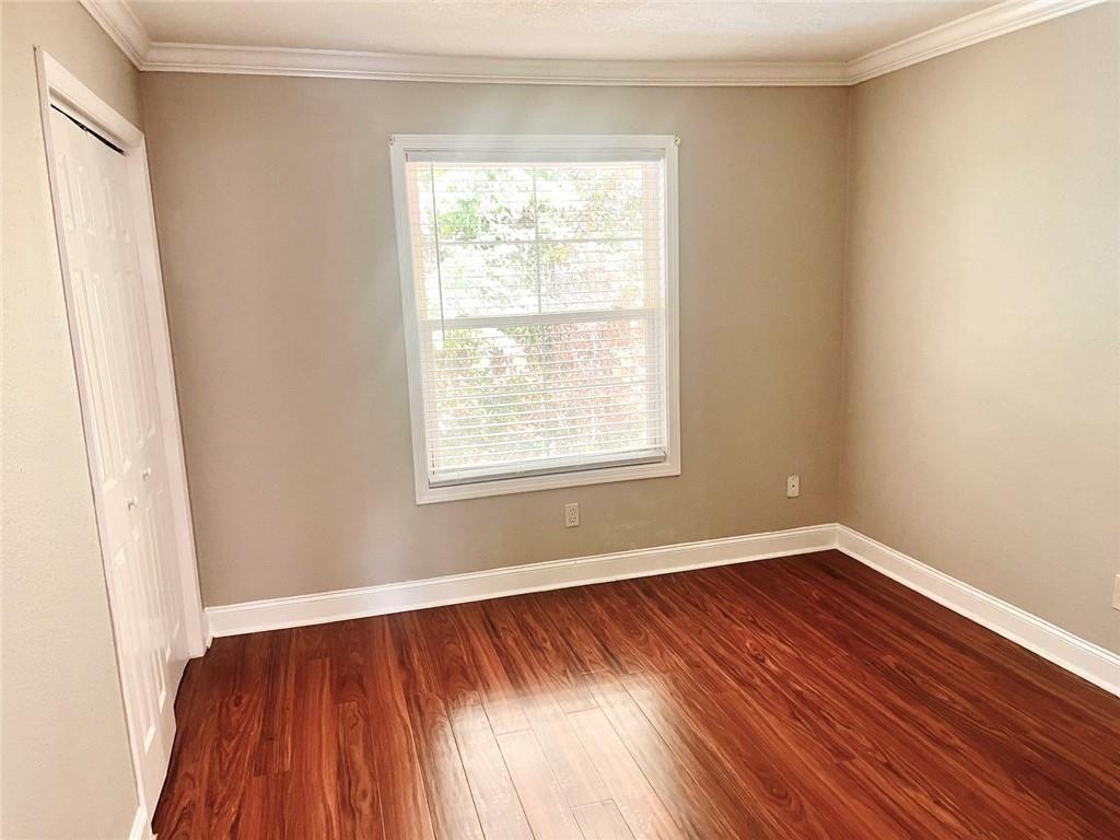 4430 Tilly Mill Road, Unit 104 Dunwoody, GA 30360 - Photo 30 of 37 an empty room with wooden floor and windows