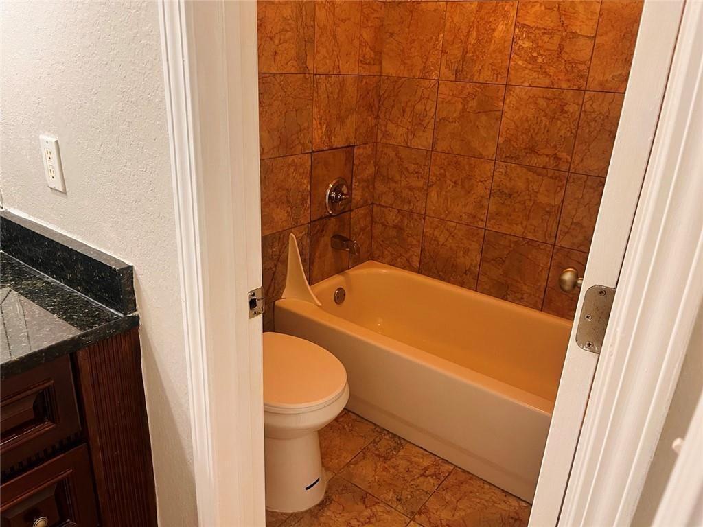 4430 Tilly Mill Road, Unit 104 Dunwoody, GA 30360 - Photo 33 of 37 a bathroom with a granite countertop bathtub shower and toilet