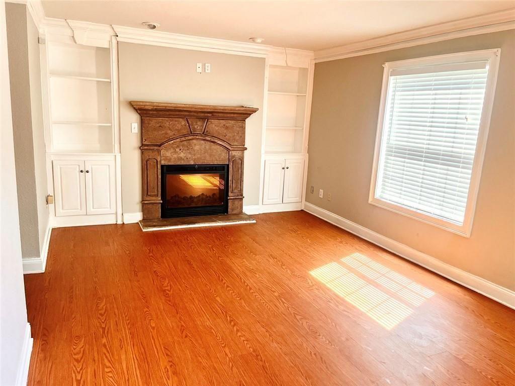 4430 Tilly Mill Road, Unit 104 Dunwoody, GA 30360 - Photo 10 of 37 a living room with a fireplace and a floor to ceiling window