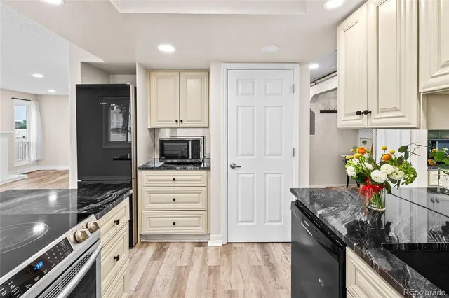 a kitchen with white cabinets and appliances