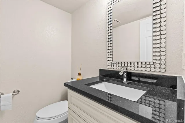 a bathroom with a granite countertop sink and a mirror