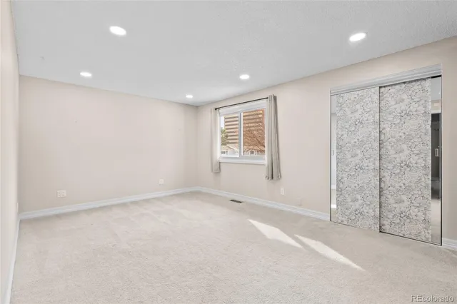 an empty room with windows and closet