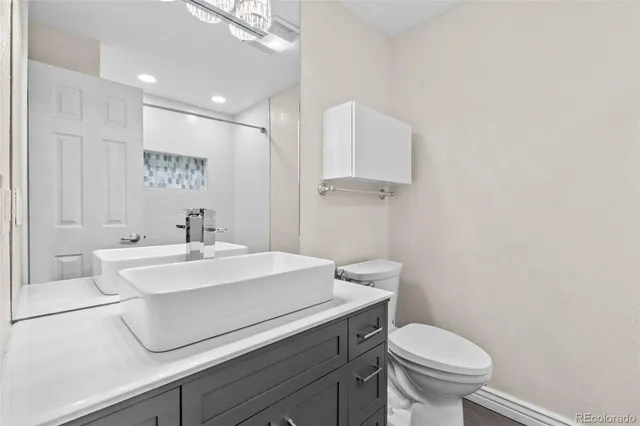 a bathroom with a sink a toilet a mirror and vanity