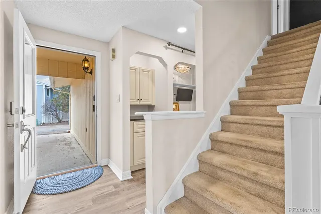 a view of an entryway with wooden floor and a living room