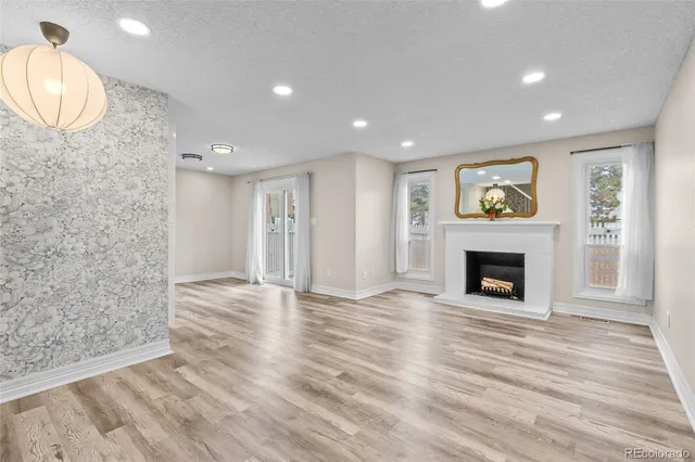 a view of a livingroom with wooden floor and a fireplace