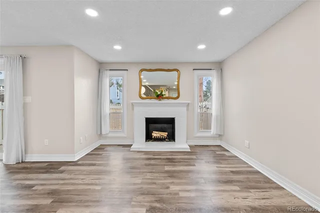 a view of a livingroom with a fireplace wooden floor and window