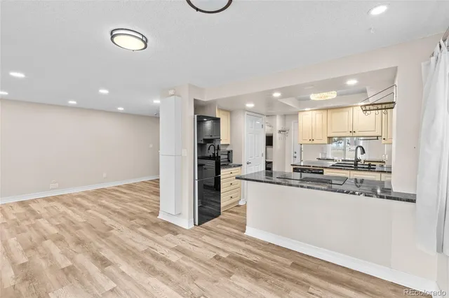 a kitchen with stainless steel appliances kitchen island granite countertop a refrigerator and a sink