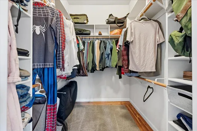 a view of walk in closet with clothes and shoes