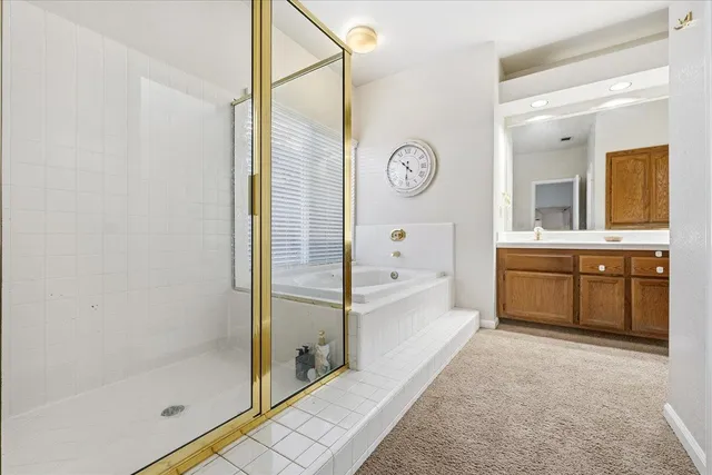 a bathroom with a tub a sink and a large mirror