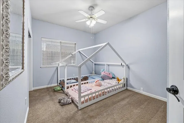 a bedroom with a bed and a ceiling fan