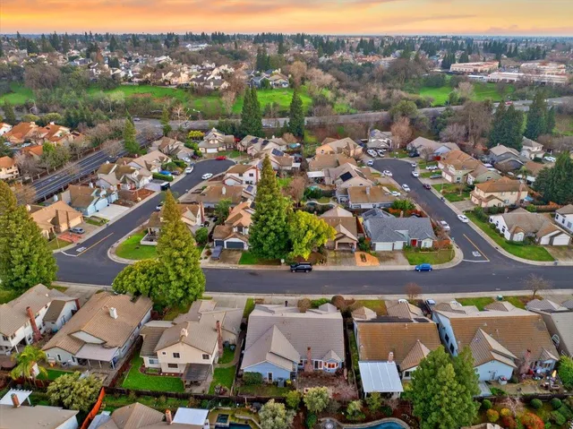 an aerial view of a city with lots of residential buildings ocean and mountain view in back