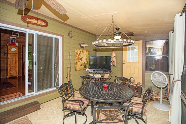 a dining room with furniture a chandelier and wooden floor