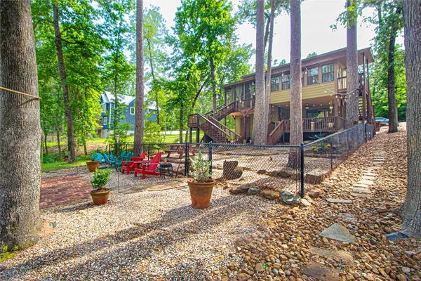 a view of a park with large trees and a wooden fence