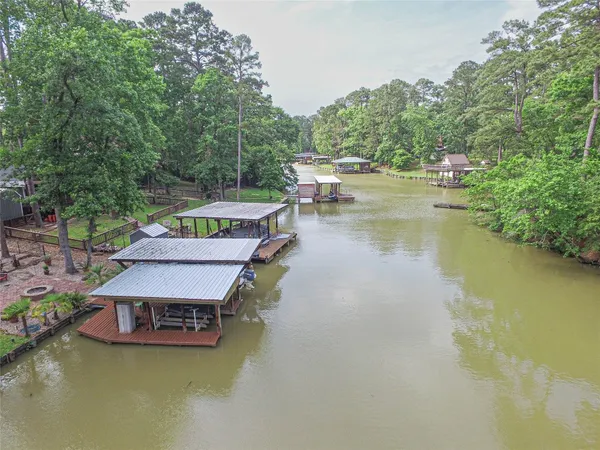 an aerial view of residential houses with outdoor space and lake view
