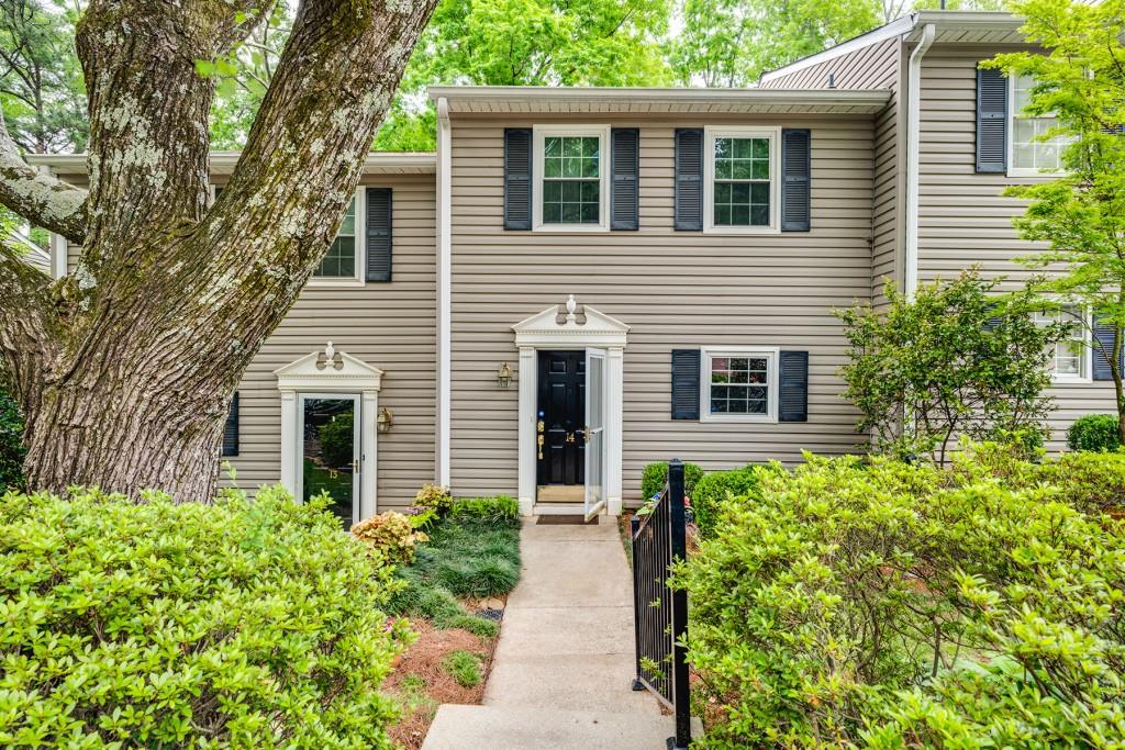 1750 Clairmont Road, Unit 14 Decatur, GA 30033 - Photo 1 of 1 a view of a house with potted plants and a large tree