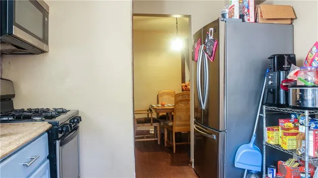 a kitchen with stainless steel appliances granite countertop a refrigerator and a stove