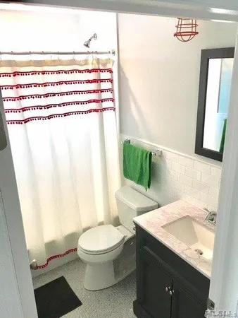 a bathroom with a sink and mirror with toilet
