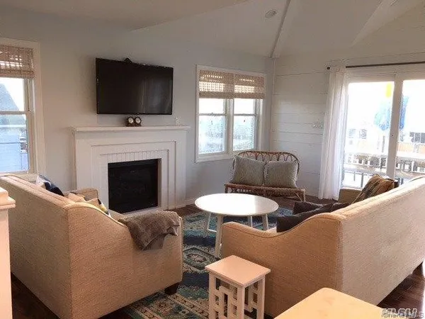 a living room with furniture a flat screen tv and a fireplace