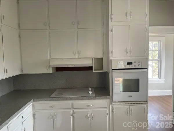 a kitchen with white cabinets and a stove