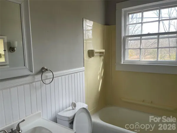 a bathroom with a tub sink and mirror