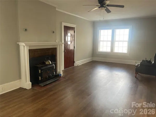 a view of an empty room with a fireplace and a window