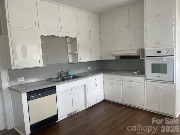 a kitchen with granite countertop white cabinets and white appliances