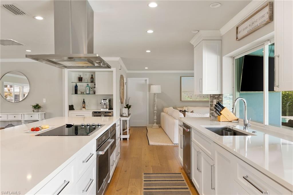 2140 Shad Court Naples, FL 34102 - Photo 27 of 44 a kitchen with counter top space a sink and cabinets