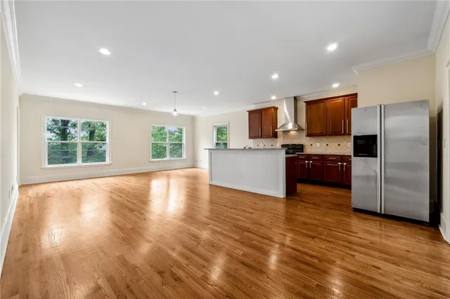 a view of kitchen with microwave a refrigerator and a stove top oven